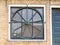 Window with round wheel of steel, part of facade of house in old