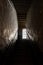 Window shining into basement with light rays shining into dark creepy cellar from stone worn staircase