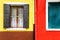 Window with shutters open on a yellow and red wall background. Copy space.