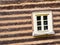 Window in wall from logs and joints erased with clay