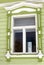 A window of a wooden county house decorated by white frames