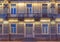 Windows, door and balcony on night facade of apartment building