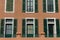 Windows with green wooden shutters. Facade of old building. Traditional ancient architecture in Europe.