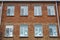 Windows of  old red brick building. Christmas decor on the glass