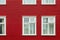 Windows on a red painted wall, colorful house, architecture detail in Reykjavik Iceland