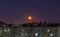 Windows, roofs and facade of an mass apartment buildings in Russia at full moon night.