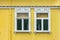 Windows on a yellow painted wall, colorful house, architecture detail in Reykjavik Iceland