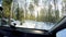 Windscreen view driving through a beautiful snowy forest winter road