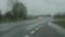 Windscreen wipers cleaning windshield glass on rainy day.