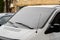 The windshield of the frozen minibus is covered with ice and snow on a winter day. Close up