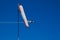 Windsock and acrobatic airplane in background on blue sky