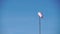 Windsock with red and white stripes show direction of wind blowing and speed. Cone wind indicator develops on blue sky background