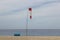 Windsock on the seashore, small house, yellow sand, blue sky