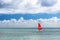 Windsurf with red sail. Water sports on vacations