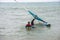 windsurfer with a board on a tropical beach, makes water start