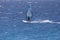 The windsurfer on the board under the sail moves along the surface of the sea with the speed of the wind, against the