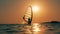Windsurfer is crossing the sea in the setting sun