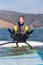 Windsurfer doing yoga while sitting on surfboard. Sport and relaxation concept