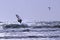 Windsurfer jumping and kitesurfer in the distance at the Atlantic ocean