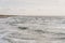 Windsurfer in the ocean waves and groynes in between on a sunny afternoon