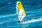 Windsurfer riding the waves with the yellow sail