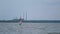 Windsurfer Sails along the Waves of the River in Cloudy Weather against the Background of Industrial Factory Pipes