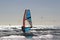 Windsurfer among the shore break of the Atlantic ocean glistening in the sun, in back light