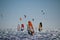 Windsurfers and kiteboarders on choppy sea, in backlight