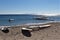 Windsurfing board and sail turned up on a sandy beach.