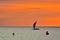 Windsurfing boat in sea and red sunset