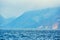 Windsurfing on lake landscape and foggy mountains at background. Man Windsurfer on the Board with a sail floating on the lake