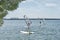 Windsurfing training. Several children floating on boards with sail on lake