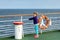 Windswept little girl hanging unto railing of ferry