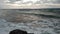 Windy chopy sea with splashing waves at sunset Tsalos beach