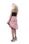 Windy concept. Back view of blonde young woman holding skirt with flying hair motion.