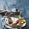 Wine appetizer set. Glass of red wine, vintage dinnerware, brushetta with cherry, dried tomatoes, arugula, parmesan, smoked meat