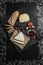 Wine appetizers set: cheese selection, bread sticks and prunes on the wood serving board background. Top view