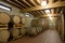 Wine barrels stacked in the old cellar of the winery,