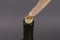 Wine bottle with broken cork and finger on gray background
