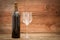 Wine bottle and elegant glass on wooden boards