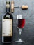 Wine bottle, wine glass and corkscrew on the graphite board.