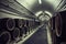 Wine cellar with rows of wooden barrels in underground corridor, vintage toned