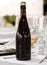 Wine champagne cider dark glass bottle blanck space in fancy table set in restaurant event celebration