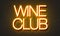 Wine club neon sign on brick wall background.