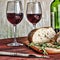 Wine in a glass, bread chiabatta and rosemary on a wooden table. The concept: sadness, loneliness