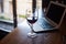 Wine glass with red wine and laptop computer.