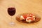 Wine glass with red wine and sandwiches with red caviar.