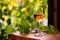 wine glass on table with vibrant vine leaves in background