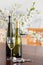 Wine glass and white wine bottles in front of a blurred bouquet