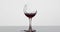 Wine. Red wine pouring in broken wine glass on the wet surface